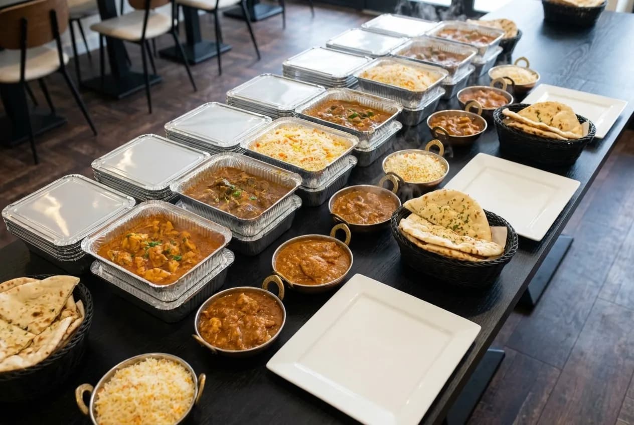 Warmhoudbakken met curry, rijst en naan, klaar om mee te nemen