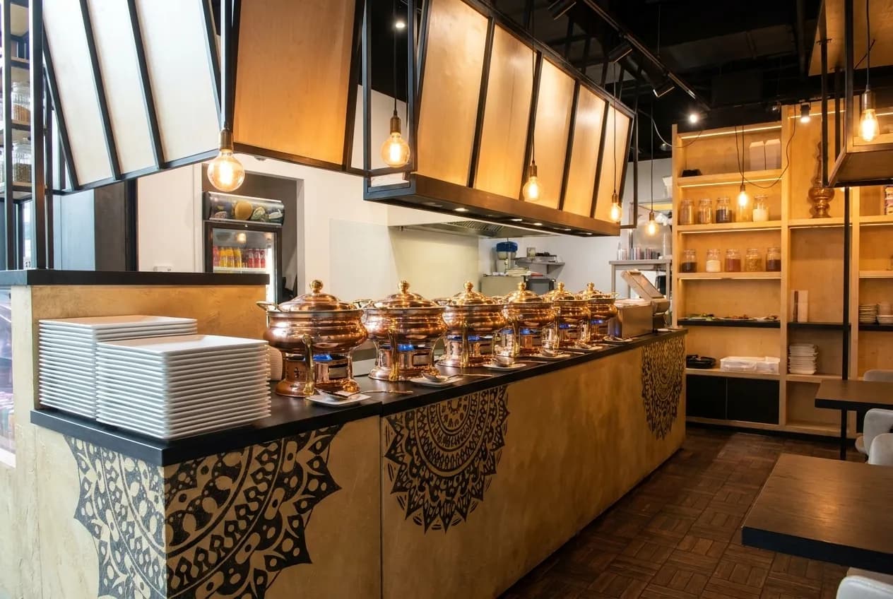 Een buffetlijn met chafing dishes en stapels witte borden